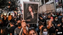 Протестиращи в Турция държат снимка на починалата иранка Махса Амини. Демонстрации с искания за премахване на задължението за носене на хиджаб в Иран се проведоха по целия свят.