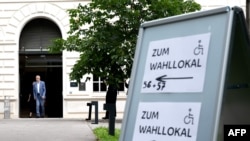 Președintele austriac Alexander Van Der Bellen și soția sa Doris Schmidauer ies din secția de votare pe 9 iunie 2024 - Viena, Austria