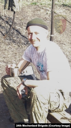 Un soldat rus ține în mână unul dintre obiectivele aparatului foto.