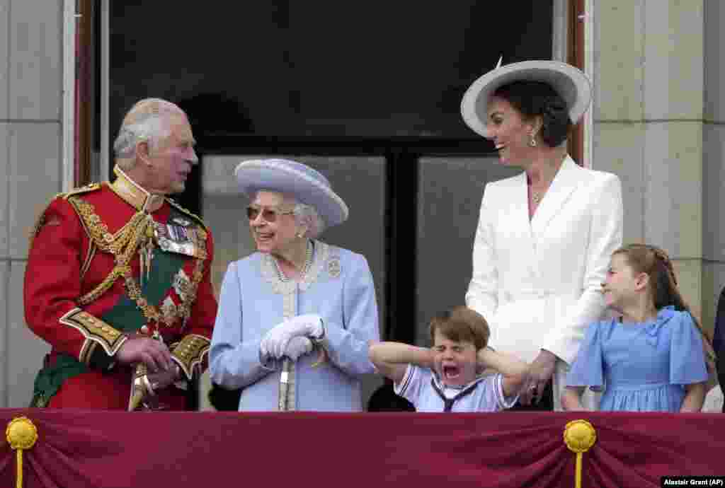 Britanski princ Čarls, levo, sa kraljicom Elizabetom II, princom Luisom njenim praunukom, koji pokriva uši rukama, pored njegove majke Kejt, vojvotkinje od Kembridža i princeze Šarlote, njene ćerke, desno, stoje na balkonu Bakingemske palate, London, četvrtak, 2. juna 2022., tokom prvog od četiri dana proslave povodom obeležavanja kraljičinog platinastog jubileja. Događaji tokom dugog prazničnog vikenda u Velikoj Britaniji imaju za cilj da proslave 70 godina monarhove službe. 