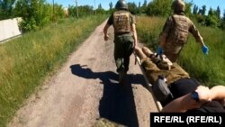 Украинските воени медицинари носат ранет војник