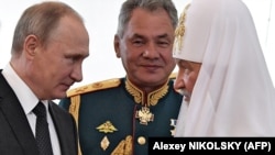 Руският президент Владимир Путин (вляво), военният министър Сергей Шойгу (в средата) и руският патриарх Кирил по време на публично събитие през 2017 г.