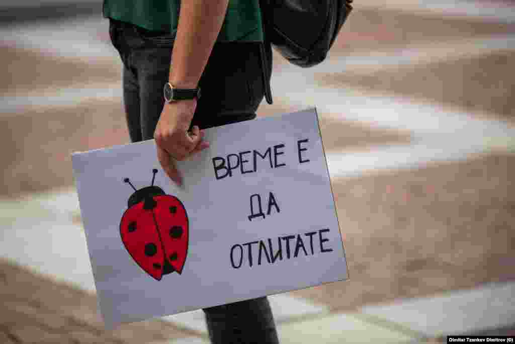 Протестант во Пловдив со плакат на кој пишува „Време е да одлетате“.