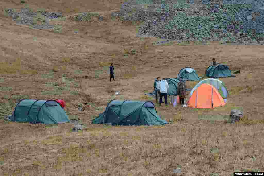 На этом фото – палаточный лагерь участников Beken Ata Expeditions: Sacred QyzEmshek. Рядом с лагерем протекает ручей, который едва просматривается под густо поросшей вдоль него травой. Считается, что именно наличие здесь воды привлекает диких животных. А вслед за ними сюда шли люди древних эпох, чей быт и чью культуру наши современники пытаются реконструировать. Высота над уровнем – моря 3000–3100 метров. Хотя это место считается относительно защищенным от сильных ветров, условия для проживания здесь довольно суровые. Ночью в емкостях с водой образовывались куски льда. Несколько раз местность и лагерь накрывало дождем или мокрым снегом. В первый день участники экспедиции археологией не занимались. Они осваивались, привыкали к месту временного пребывания.