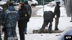 Anchetatori și experți ai poliției lucrează lângă un cadavru la locul exploziei, care l-a ucis pe comandantul trupelor de apărare nucleară, biologică și chimică ale forțelor armate ruse, Igor Kirilov, și pe asistentul său.