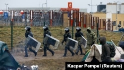 Беларускія сілавікі ў стыхійным лягеры мігрантаў на беларускім баку мяжы паблізу ад пераходу «Брузгі» — «Кузьніца» 18 лістапада 2021 году. Ілюстрацыйнае фота