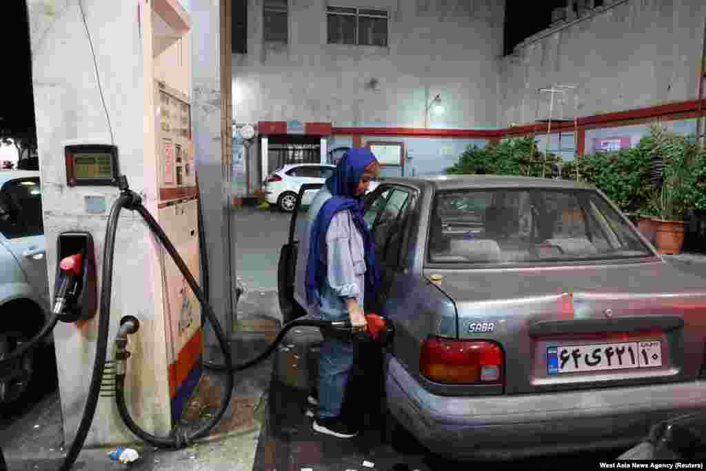An Iranian woman fills up her car in Tehran amid fears an Israeli attack could target Iran's oil industry. 