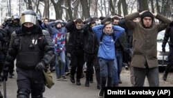 RUSSIA – Detained protesters walk escorted by Російські силовики жорстоко розгяняють мирні протести. Більшість затримань було в Москві (понад 900 осіб) та Санкт-Петербурзі (більше 600). Пітер, Росія. 31 січня 2021 року
