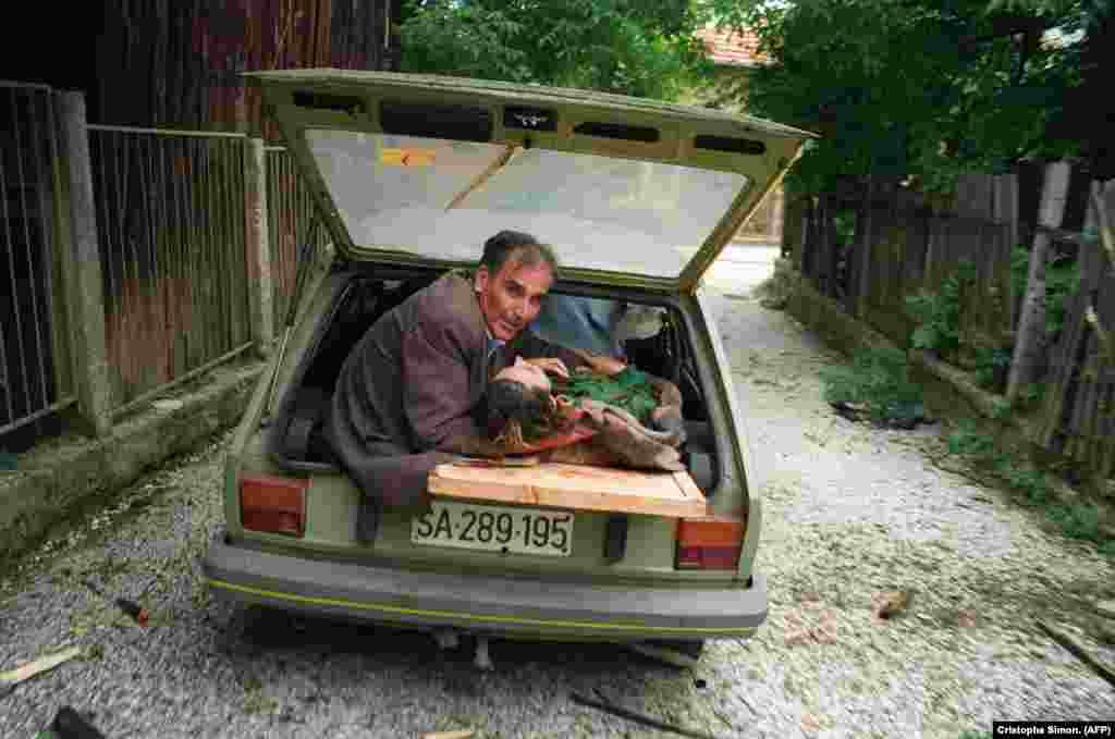Čovjek drži glavu žene ranjene u granatiranju, 27. juni 1992. 