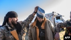 Vojnici Sirijskih demokratskih snaga, u Baghouzu, posljednjem uporištu tzv. Islamske države, pretresaju Edvina Babića, muškarca iz Sarajeva koji je navodno bio pripadnik ove militantne organizacije, 1. mart 2019. godine. 