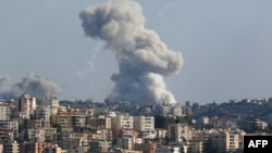 Fumul se ridică deasupra unei localități din Libanul de sud, după un bombardament israelian, la 23 septembrie.