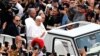 Papa Francisc salutând mulțimea în duminica Paștelui, în prima sa plimbare în aer liber cu papamobilul prin Piața Sfântului Petru de la Vatican de după cele cinci săptămâni petrecute la spital cu pneomonie bilaterală, 20 aprilie 2025. 