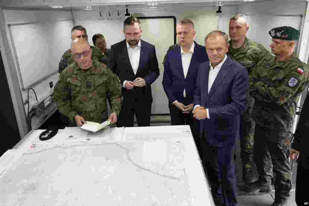 Donald Tusk lengyel miniszterelnök (elöl jobbra) május 29-én a kelet-lengyelországi Dubicze Cerkiewnéban tett látogatása során. „Nem akármilyen menedékkérőkkel van dolgunk, hanem egy összehangolt, nagyon hatékony, több szinten is a lengyel határ áttörésére irányuló művelettel és az ország destabilizálására irányuló kísérletekkel” – mondta