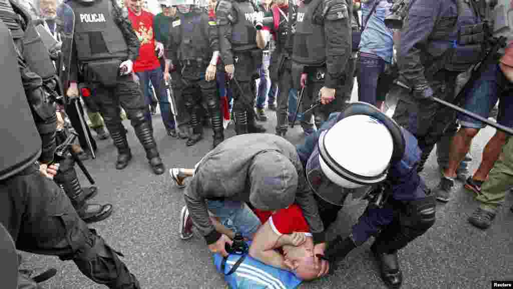 An injured Polish soccer fan lies on the ground after clashing with Russian supporters in Warsaw.