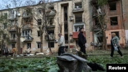 Місцеві жителі проходять повз житлового будинку, пошкодженого російським авіаударом у Харкові, Україна, 5 травня 2024 року. Фото ілюстративне
