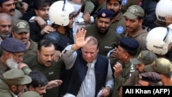 Police escort former Pakistani prime minister Nawaz Sharif (C) as he leaves the accountability court in the eastern city of Lahore in October 2019.