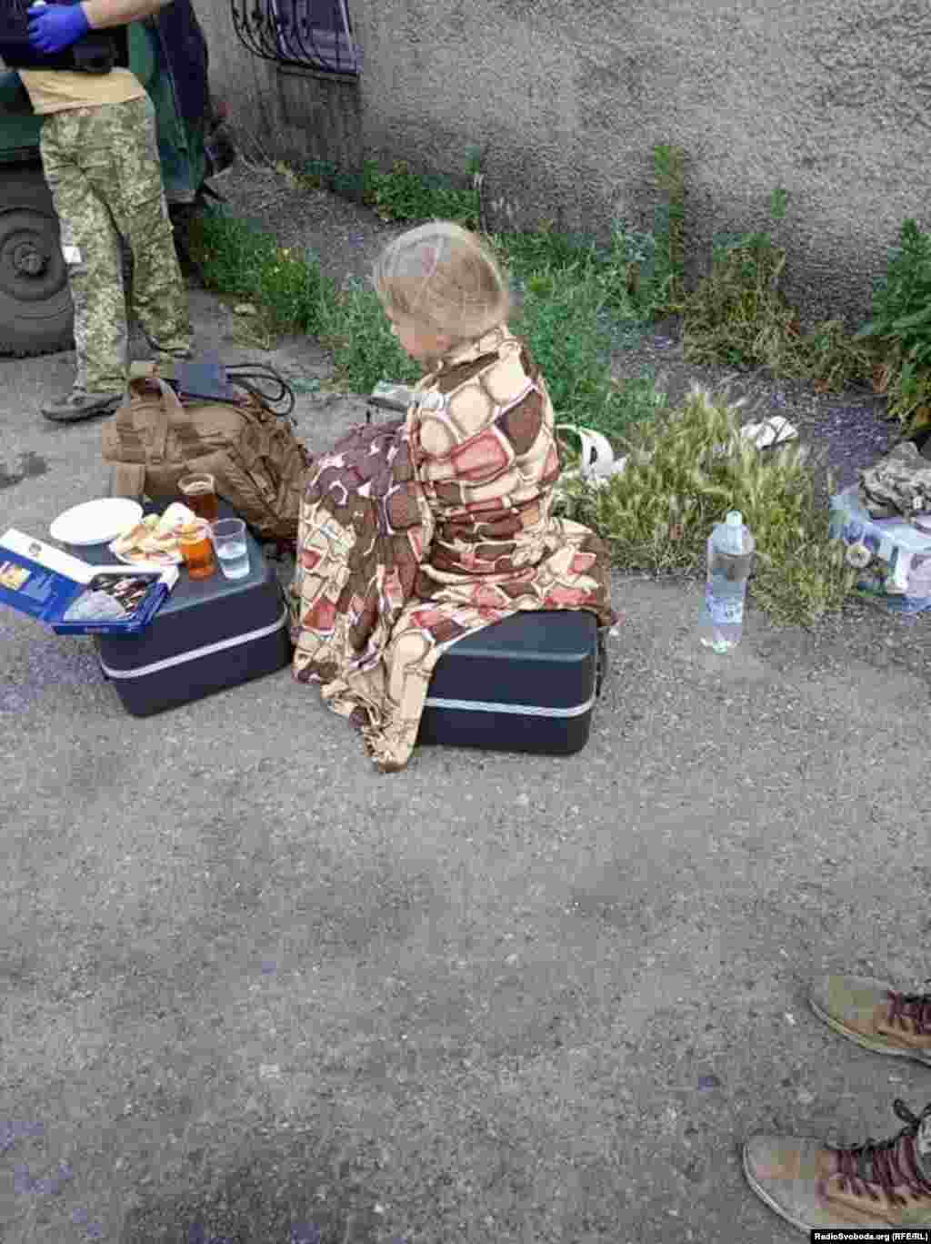 Дев'ятирічна дівчинка після надання першої медичної допомоги біля розбитого снарядом будинку в Мар'їнці. Внаслідок артобстрілу селища російськими гібридними силами поранено щонайменше четверо цивільних. Мар'їнка, Донецька область, 14 червня 2019 року (фото надано 24 ОМБР). БІЛЬШЕ ПРО ЦЕ