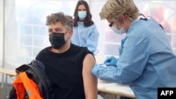Човек прима вакцина од Модерна, во шатор на Црвениот крст во Петриња, 13 јануари 2021 година