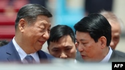 Președintele Chinei, Xi Jinping (s), discută cu președintele Vietnamului, Luong Cuong (d), la începutul vizitei de stat pe care o face la Hanoi, pe 14 aprilie 2025.