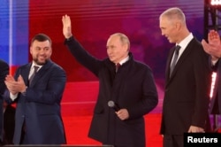 Президент Росії Володимир Путін (у центрі), Денис Пушилін (ліворуч) та Володимир Сальдо (праворуч), призначені Кремлем так звані керівники Донецької та Херсонської областей, на концерті, присвяченому проголошеній анексії окупованих Росією територій чотирьох областей України. Москва, Росія, 30 вересня 2022 року