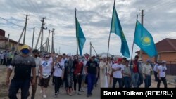 Ағаділ асына келгендер ту көтеріп, белсендінің бейітіне бара жатыр. Ақмола облысы, Талапкер ауылы, 8 тамыз 2020 жыл.