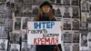 Громадська активістка під час акції протесту біля офісу телеканалу «Інтер» на тлі фотографій українських воїнів, які загинули на Донбасі у війні України проти Росії. Київ, 11 грудня 2014 року