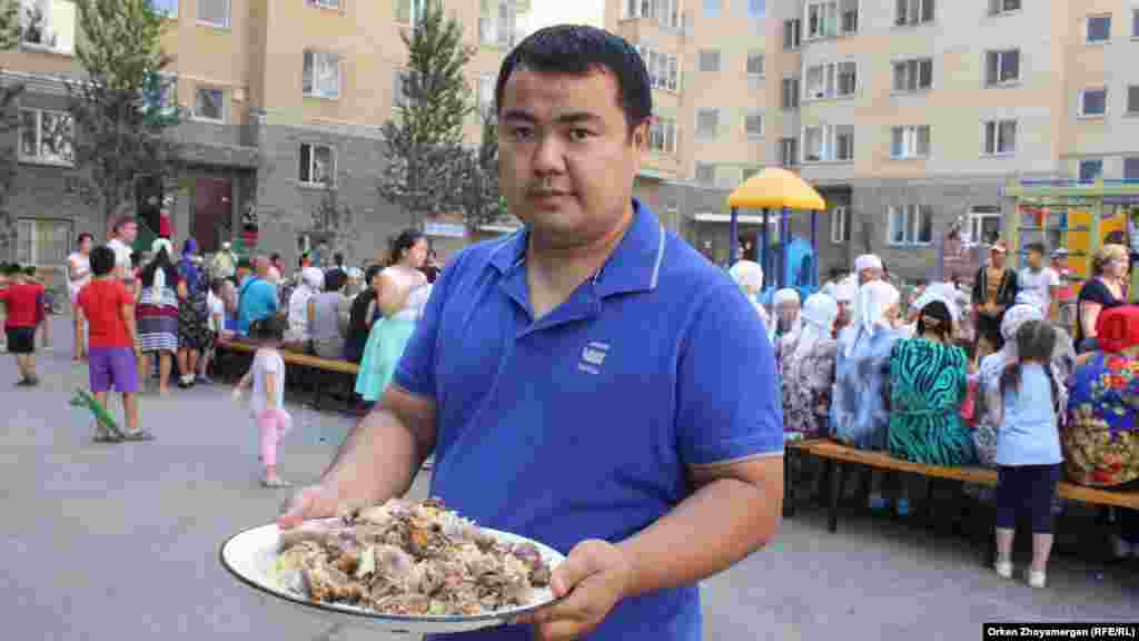Молодой человек несет блюдо с праздничной едой. 