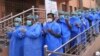 FILE: Hospital staff pray before begging their work shift outside a hospital for coronavirus infected patients in the southwestern city of Quetta on March 26.