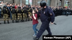 Поліцейський затримує дівчину-підлітка під час акції протесту в російському Петербурзі, 9 вересня 2018 року