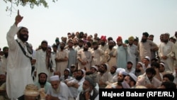 FILE: In the absence of state courts, parties to a conflict often make heated arguments while making their case before a tribal jirga or council. Here, the residents of the town of Bara in the Khyber tribal district debate the fate of minority Sikhs threatened by a fanatical cleric in 2002.