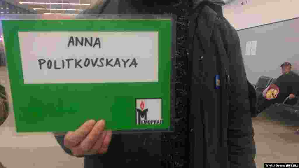 Гражданский активист держит в аэропорту табличку с именем убитой российской журналистки Анны Политковской. Журналист освещала нарушения прав человека во время войн в Чечне и была застрелена в лифте своего дома в центре Москвы 7 октября 2006 года. Прага, 2 апреля 2015 года. 