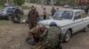 Tetyana, 75, an evacuee from the town of Vovchansk, stands next to the car in which she and her husband fled as they arrive at an evacuation point in the Kharkiv region on May 12.
