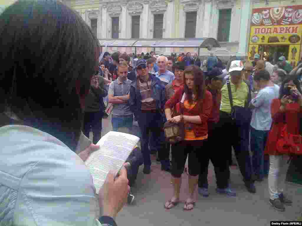 Гражданские активисты на Старом Арбате по очереди зачитывают закон о полиции