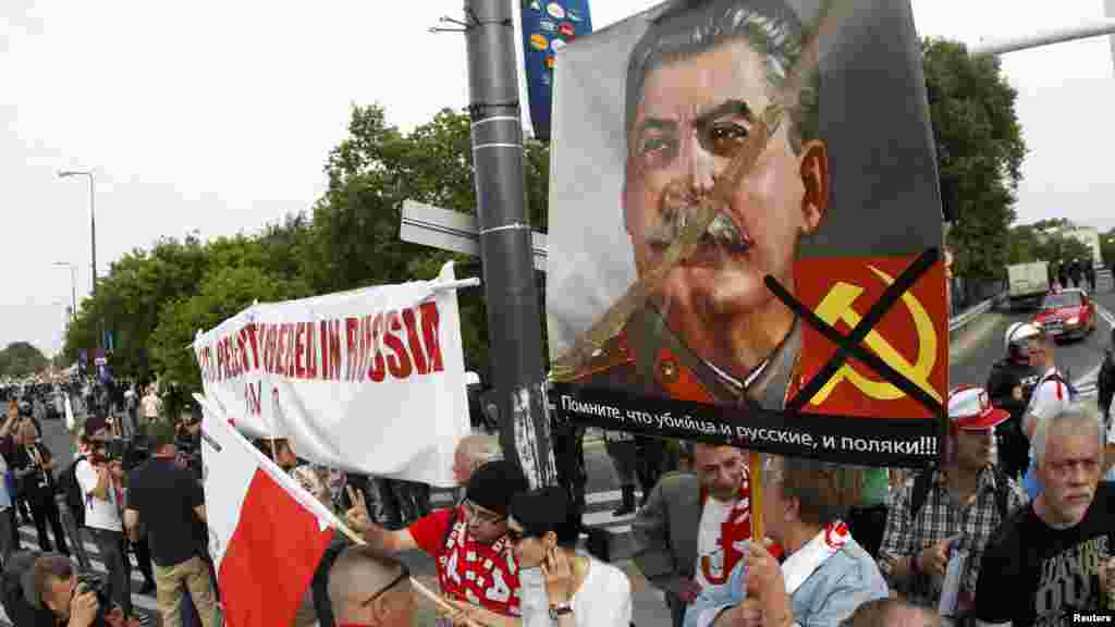 Polish protesters walk with a placard reading "Russians and Poles, remember who is the killer!" and depicting Soviet dictator Josef Stalin during a rally in Warsaw.