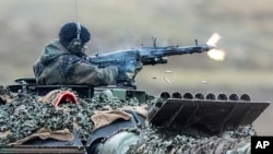 Нямецкі салдат страляе з кулямёта на танку Leopard 2, 203-і танкавы батальён ў Аўгустдорфе, Нямеччына, 2023 год