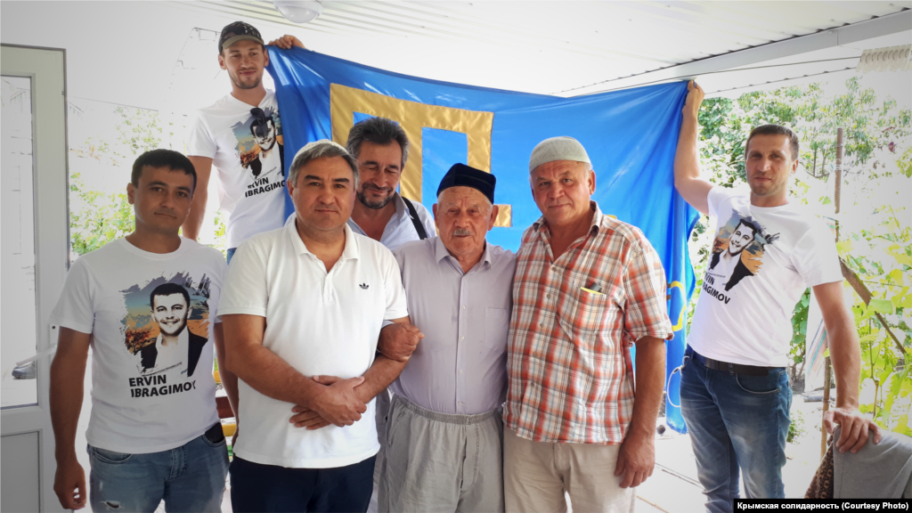 Июнь 2020. Крымскотатарские активисты в гостях у ветерана национального движения Джеппара Абдуджемилева. Их визит – часть марафона, приуроченного ко дню флага. Акция стартовала 24 июня и за эти несколько дней ее участники планировали объездить с крымскотатарским флагом весь Крым, попутно наведываясь к ветеранам. В финале же флаг подняли на скалу Ак-Кая (Белая скала) в Белогорском районе