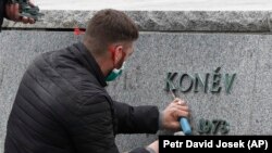 Un muncitor îndepărtează inscripția de pe piedestalul statuii mareșalul sovietic Ivan Konev, după ce aceasta a fost îndepărtată de pe locul său din Praga, 3 aprilie 2020.