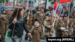 Copii obligați să poarte uniforme militare la o defilare organizată de ocupanții ruși în Sevastopol, peninsula ucraineană Crimeea anexată de Rusia, 9 mai 2019.
