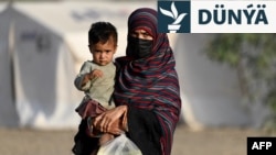 Nangarhar welaýatynda Owganystan-Pakistan Torkham serhediniň golaýyndaky bosgun lagerine Pakistandan baran çagaly owgan zenany. 20-nji aprel, 2025. 