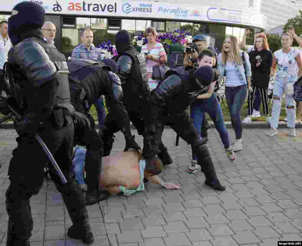 Bezbednosne snage dok savladavaju demonstranta u Minsku.