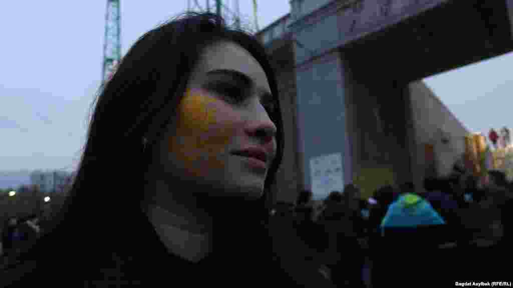 Девушка с изображением солнца на лице. Солнце — один из элементов флага Казахстана.
