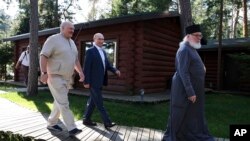 Una din cele mai recente fotografii ale liderului de la Minsk (în stânga) îl arată în compania lui Putin și a unui monah la o mănăstire din Karelia, pe 26 iulie 2024.