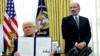 Američki predsednik Donald Tramp pokazuje potpisanu izvršnu naredbu o povećanju carina u prisustvu ministra trgovine Hauarda Lutnika u Vašingtonu, SAD, februar 2025.