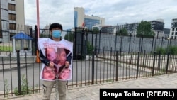 Житель Алматы Акикат Калиолла у здания посольства Китая проводит одиночную акцию в защиту родственников, которых, по его словам, удерживают в Синьцзяне (Китай). Нур-Султан, 26 июня 2020 года.