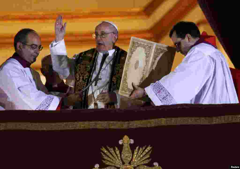 Noul Papă Francisc, cardinalul Jorge Mario Bergoglio din Argentina, binecuvântează miile de credincioşi adnaţi în piaţa Catedralei St. Petru, după încheierea conclavului papal la Vatican. 13 martie 2013.