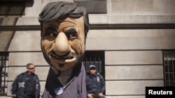 New York police officers look at a man dressed as President Mahmud Ahmadinejad during a protest against the Iranian leader outside the Warwick Hotel in New York.