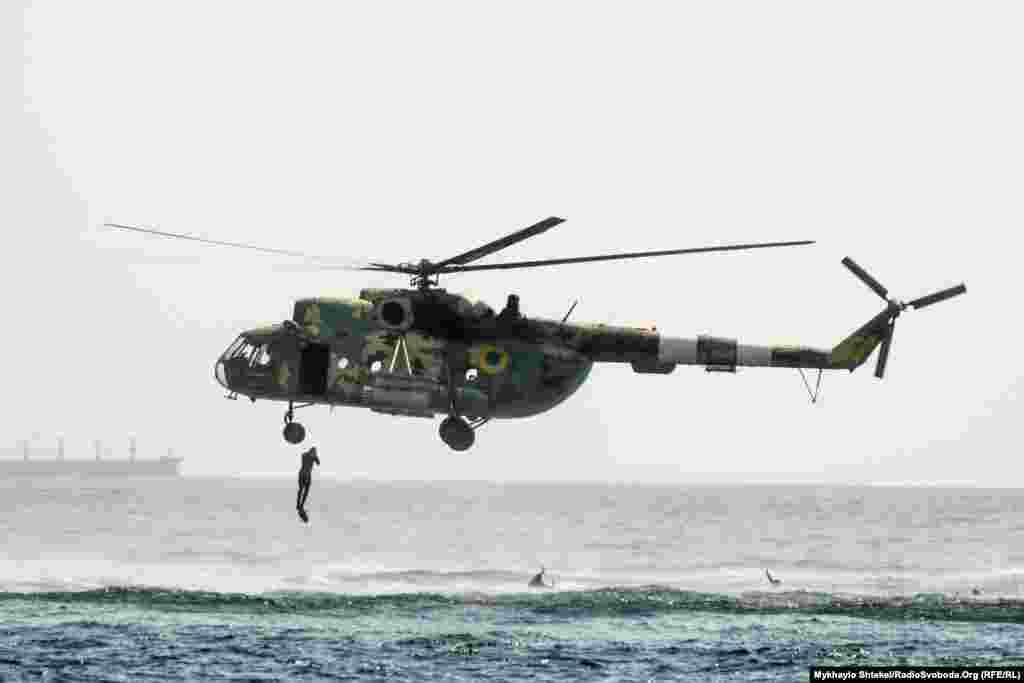 A Ukrainian soldier jumps from a military helicopter during the festivities in Odesa.