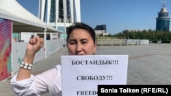 Азаматтық белсенді Әлия Жақыпова "Бостандық! Свободу!Freedom!" дегені жазуы бар қағаз ұстап тұр. Нұр-Cүлтан, 26 тамыз, 2019 жыл.