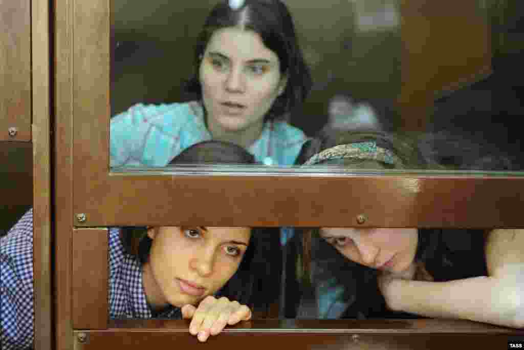 Участницы феминистской панк-группы "Pussy Riot" Екатерина Самуцевич (на втором плане), Надежда Толоконникова и Мария Алехина (слева направо на первом плане), обвиняемые в хулиганстве в храме Христа Спасителя, во время рассмотрения их дела в Хамо
