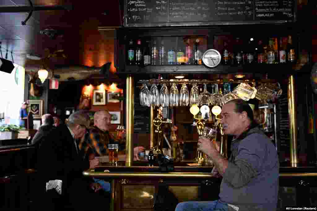Мештаните пијат пиво во „Half Way Inn“, паб во центарот на Стокхолм 
